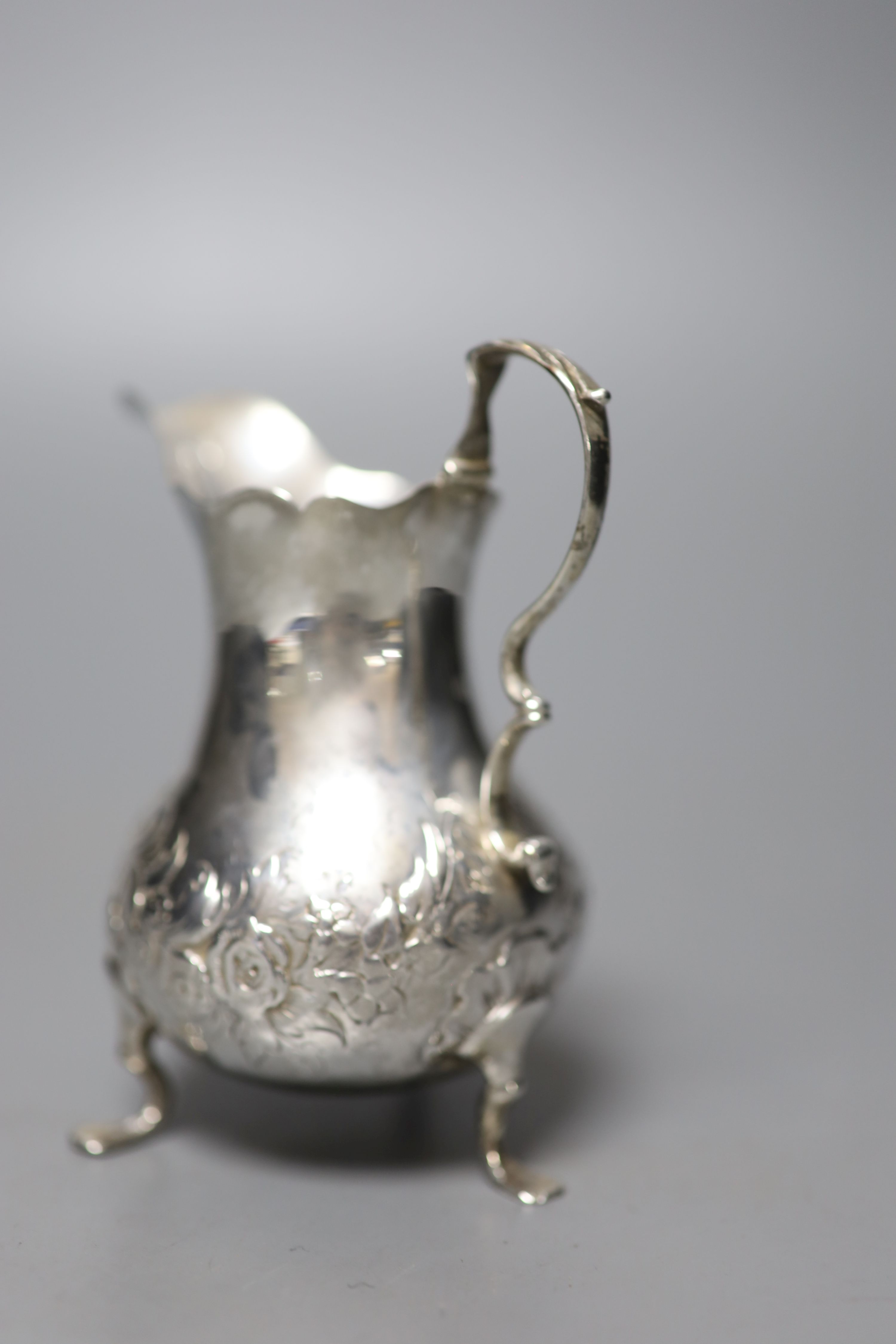 A George III silver cream jug, with later embossed decoration, London, 1767, 10cm, 61 grams.